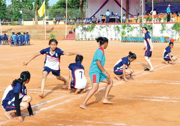 In a game of Kho Kho, how many members of chasing team enters the field and sit on their knees